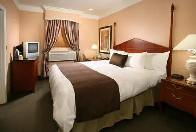 a hotel room with a large bed and a television at Brand Plaza Hotel in Glendale
