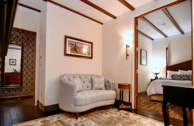 a living room with a couch and a bed at Brand Plaza Hotel in Glendale