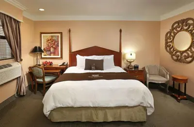 a hotel room with a large bed and a desk at Brand Plaza Hotel in Glendale