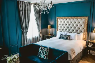 a blue bedroom with a king sized bed with a blue wall at The Culver Hotel in Los Angeles