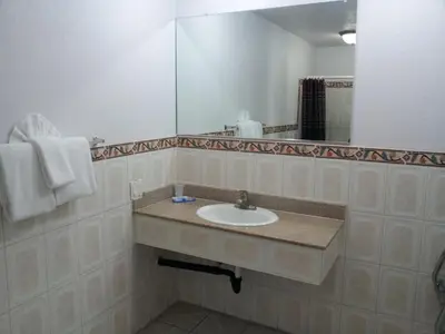 a bathroom with a sink and a large mirror at Riviera Motel in Anaheim