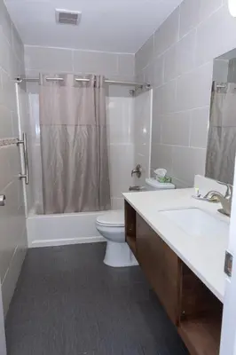 a bathroom with a toilet and a sink and a shower at Value Inn Bellflower in Bellflower