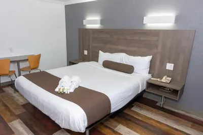 a hotel room with a bed and a desk at Value Inn Bellflower in Bellflower