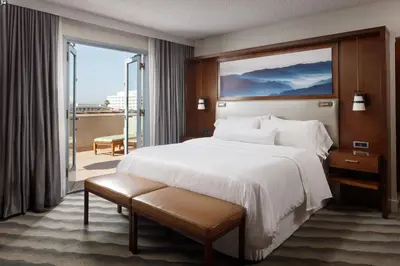 a hotel room with a large bed and a balcony at The Westin Pasadena in Pasadena