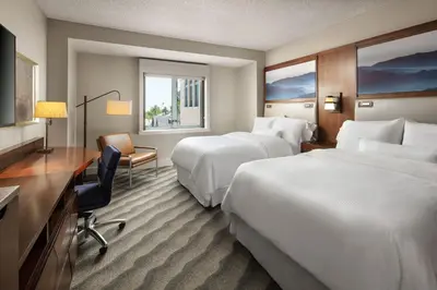a hotel room with two beds and a desk at The Westin Pasadena in Pasadena