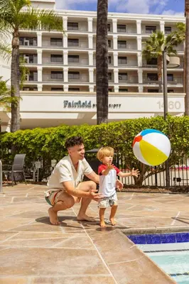 a man and a little boy playing with a beach ball at Fairfield by Marriott Anaheim Resort in Anaheim