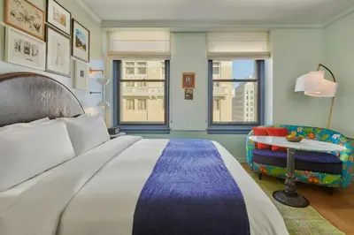 a bedroom with a large bed and a chair at Hotel Per La, Autograph Collection in Los Angeles
