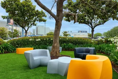 a group of chairs and a tree in a park at Renaissance Los Angeles Airport Hotel in Los Angeles