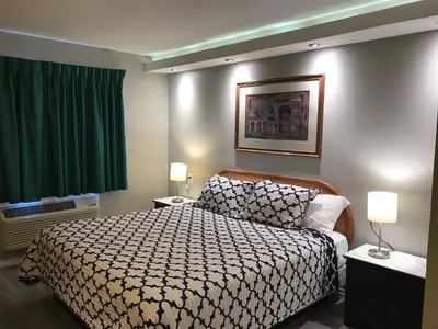 a hotel room with a bed and two lamps at 777 Motor Inn in Huntington Beach