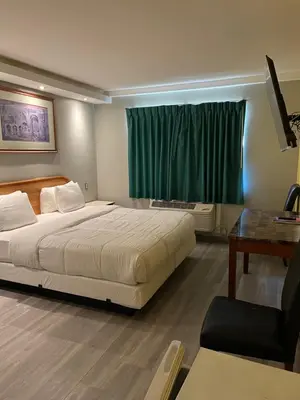 a bedroom with a bed and a desk and a window at 777 Motor Inn in Huntington Beach