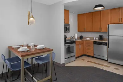 a kitchen with a table and a stainless steel refrigerator at Residence Inn Los Angeles Burbank/Downtown in Burbank