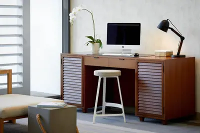 a desk with a computer on it with a stool at Westdrift Manhattan Beach, Autograph Collection in Manhattan Beach