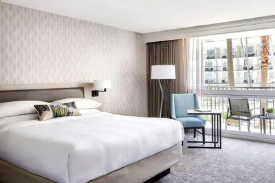 a hotel room with a bed and a chair and a window at Los Angeles Airport Marriott in Los Angeles