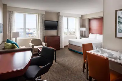 a hotel room with a bed and a living room at Residence Inn Long Beach Downtown in Long Beach