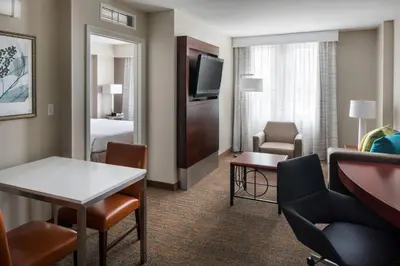 a hotel room with a bed and a living room at Residence Inn Long Beach Downtown in Long Beach