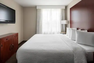 a bedroom with a large bed and a flat screen tv at Residence Inn Long Beach Downtown in Long Beach
