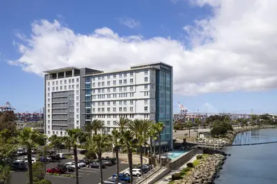a tall white building with palm trees and a river at Residence Inn Long Beach Downtown in Long Beach