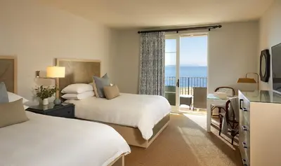 a bedroom with two beds and a view of the ocean at Terranea Resort in Rancho Palos Verdes