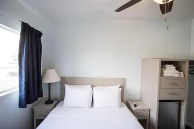 a bedroom with a bed with white sheets and a window at Ocean Park Hotel in Los Angeles