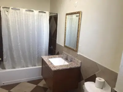 a bathroom with a sink and a toilet and a mirror at Galleria Inn Montclair/Ontario in Montclair