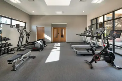 a gym with treadmills and machines in a room at Courtyard by Marriott Bakersfield in Bakersfield