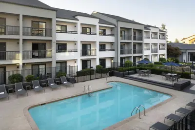 a hotel with a swimming pool in front of a building at Courtyard by Marriott Bakersfield in Bakersfield