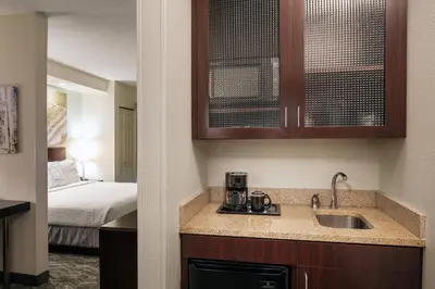 a kitchen with a sink and a bed in a room at SpringHill Suites Bakersfield in Bakersfield