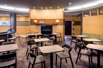 a restaurant with tables and chairs and a fireplace at SpringHill Suites Bakersfield in Bakersfield