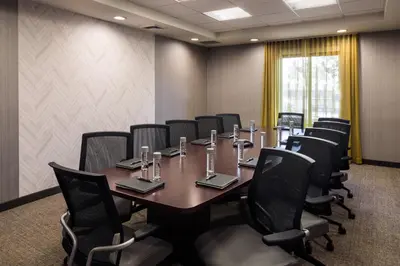 a conference room with a long table and chairs at SpringHill Suites Bakersfield in Bakersfield