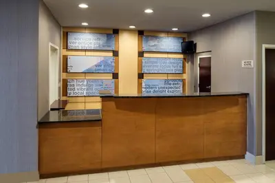 a lobby with a reception desk and signs on the wall at SpringHill Suites Bakersfield in Bakersfield
