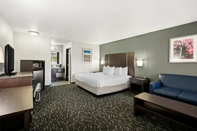 a hotel room with a bed and a couch at Best Western Desert Villa Inn in Barstow