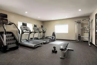 a gym with treadmills and machines in a room at Sonesta Select Los Angeles Torrance South Bay in Torrance