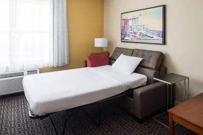 a hotel room with a bed and a couch at TownePlace Suites Los Angeles LAX Manhattan Beach in Hawthorne