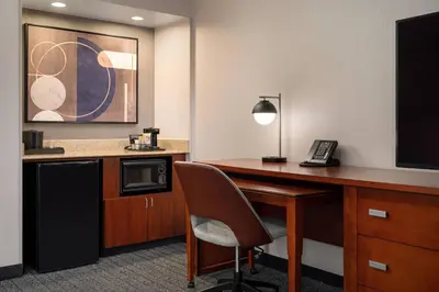 a room with a desk with a telephone and a microwave at Courtyard Los Angeles Torrance/Palos Verdes in Torrance