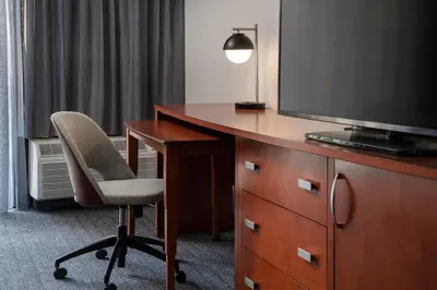 a room with a desk with a chair and a television at Courtyard Los Angeles Torrance/Palos Verdes in Torrance