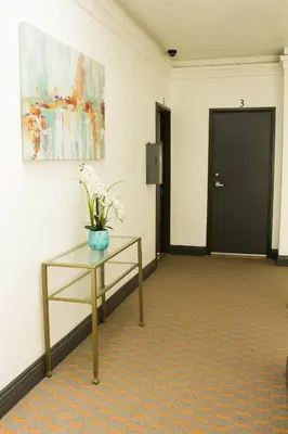a room with a table with a vase of flowers on it at Libra Hotel in Los Angeles