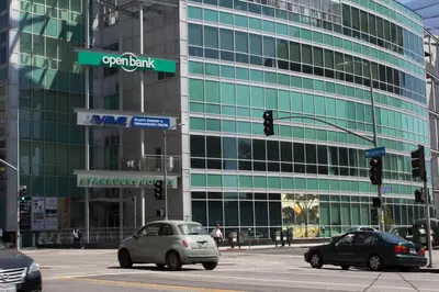 a large glass building with cars on a city street at Libra Hotel in Los Angeles