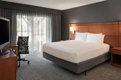 a hotel room with a bed and a television at Courtyard Anaheim Buena Park in Buena Park