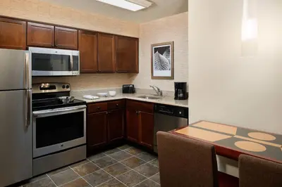 a kitchen with stainless steel appliances and a table at Residence Inn by Marriott Cypress Los Alamitos in Los Alamitos