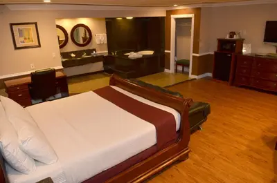 a hotel room with a bed and a desk at Dynasty Suites Hotel in Riverside