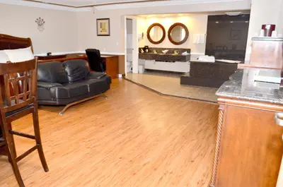 a living room with a black leather couch and a living room at Dynasty Suites Hotel in Riverside