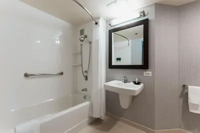 a bathroom with a sink and a tub and a mirror at Courtyard by Marriott Los Angeles LAX / Century Boulevard in Los Angeles