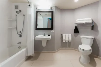 a bathroom with a toilet and a sink and a shower at Courtyard by Marriott Los Angeles LAX / Century Boulevard in Los Angeles