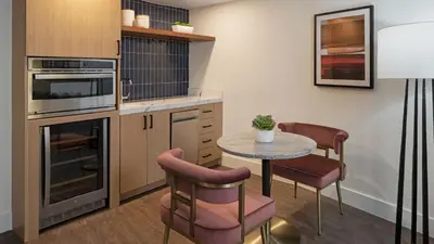 a kitchen with a table and chairs in a room at Burton House, Beverly Hills, A Tribute Portfolio Hotel in Los Angeles