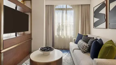 a living room with a couch and a tv at Burton House, Beverly Hills, A Tribute Portfolio Hotel in Los Angeles