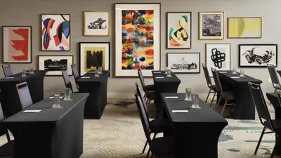 a room with tables and chairs and paintings on the wall at Burton House, Beverly Hills, A Tribute Portfolio Hotel in Los Angeles