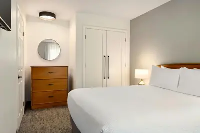 a bedroom with a bed and a dresser and a mirror at TownePlace Suites by Marriott Anaheim Maingate Near Angel Stadium in Anaheim