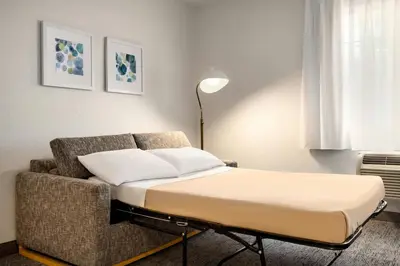 a bed and a couch in a room at TownePlace Suites by Marriott Anaheim Maingate Near Angel Stadium in Anaheim