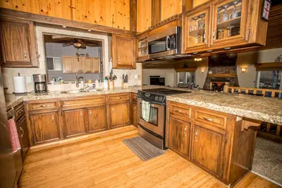 a kitchen with wooden cabinets and a stove top oven at Majestic Pines Home in Big Bear Lake