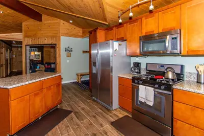 a kitchen with wooden cabinets and stainless steel appliances at Big Bear Splash Home in Big Bear Lake